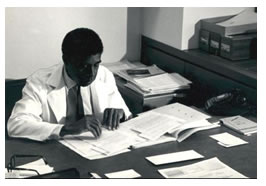 Harold Amos at his desk